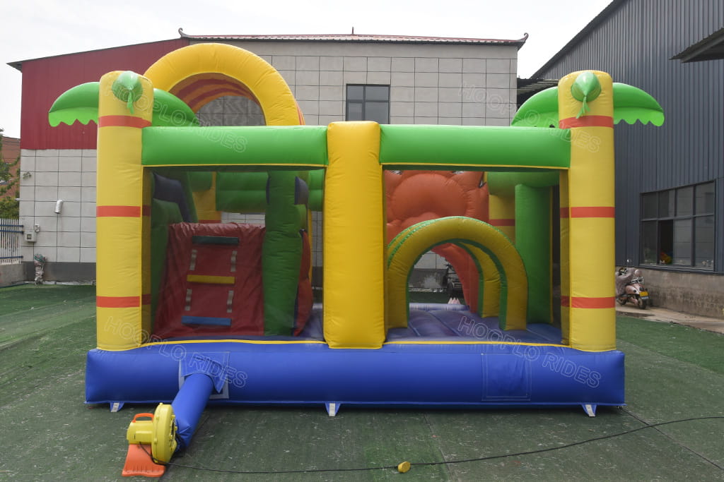 Back side of jungle lion safari inflatable bounce house combo, palm tree pillar decoration, dual play area with climbing ladder, matching electric air blower, outdoor kids party jumper