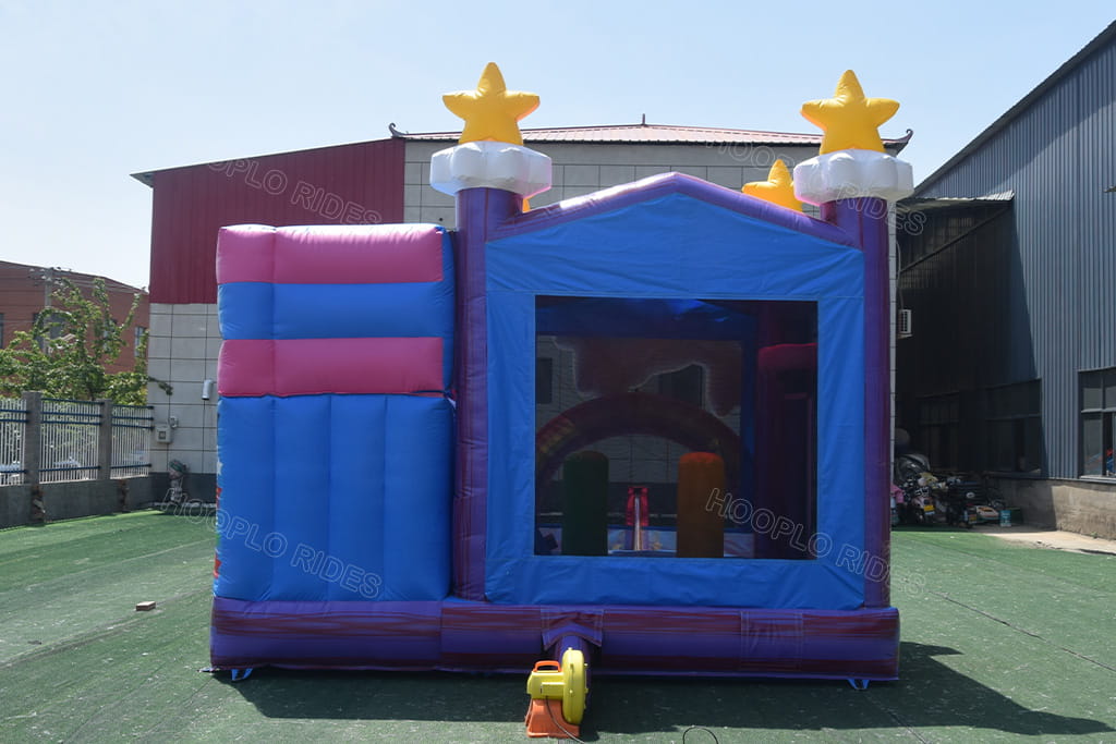 Back side of rainbow unicorn inflatable bounce house with slide, purple blue star castle design, large mesh safety window, matching electric air blower, outdoor kids party jumper