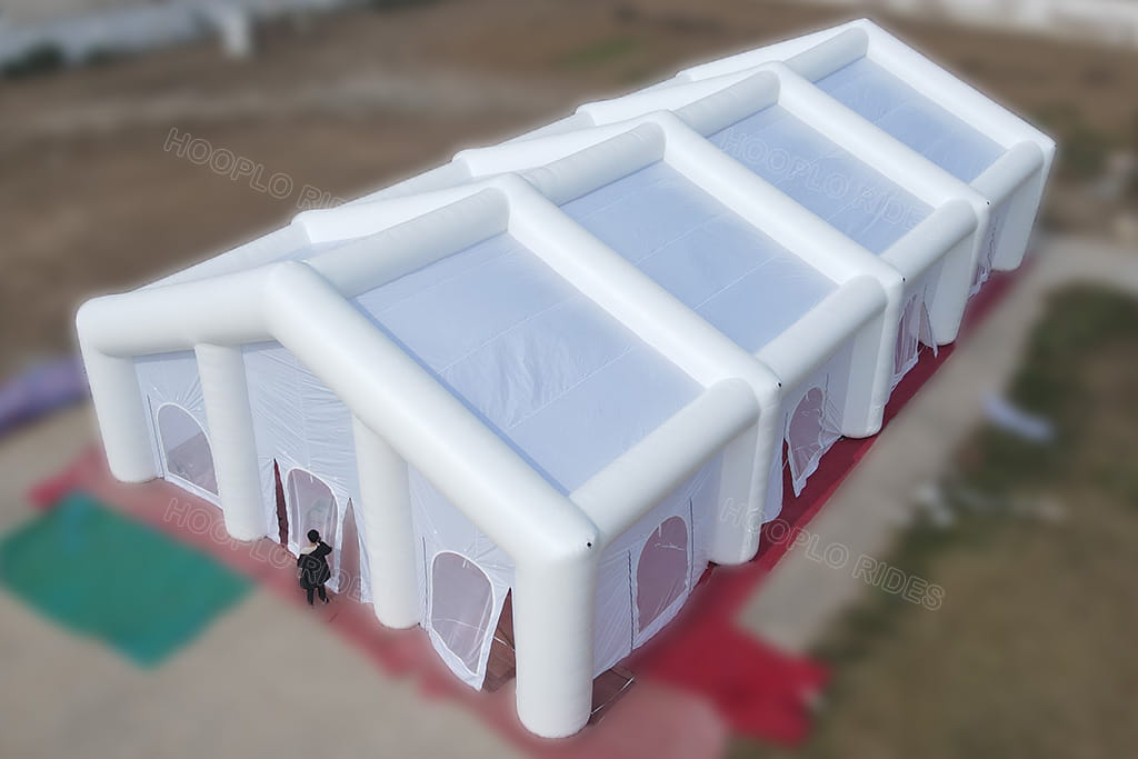 Aerial side view of 24*12m large white inflatable event tent with multiple mesh arched doors and windows, spacious inflatable venue for wedding and big outdoor parties