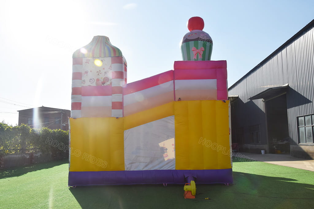 Rear back view Hooplo Candy Land Inflatable Bounce House, solid yellow back panel, matching air blower, candy bounce house with internal obstacle course for outdoor amusement