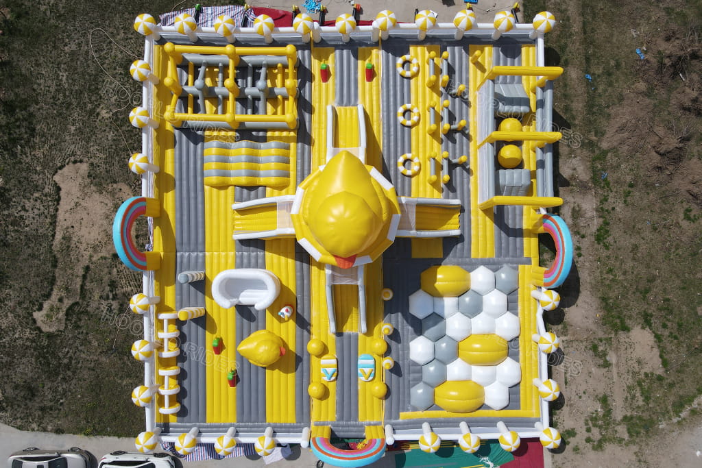 Top‑down aerial layout view of huge rubber duck inflatable playground, complete layout of large commercial inflatable obstacle jumping castle for kids