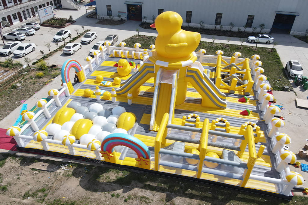 Giant yellow rubber duck inflatable obstacle course playground, commercial inflatable jumping castle equipped with double slide, rainbow arch and ball pit for kids outdoor amusement events