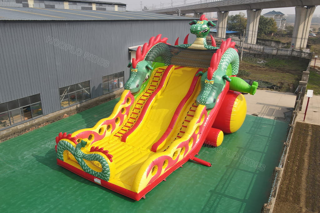 Large dragon themed dual‑lane inflatable slide 45‑degree aerial view, colorful dragon sculpture inflatable amusement slide