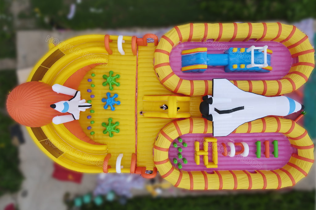 Top view of giant space themed inflatable playground with rocket and space shuttle bounce obstacle course